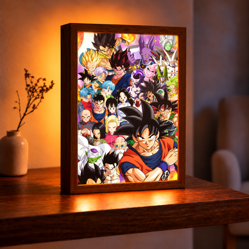 Dragon Ball Heroes illuminated art in a dark wood frame on a wooden table with warm amber lighting and a colorful Dragon Ball character ensemble