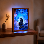 Madara Uchiha and blue Susanoo illuminated artwork in a wooden frame on a table