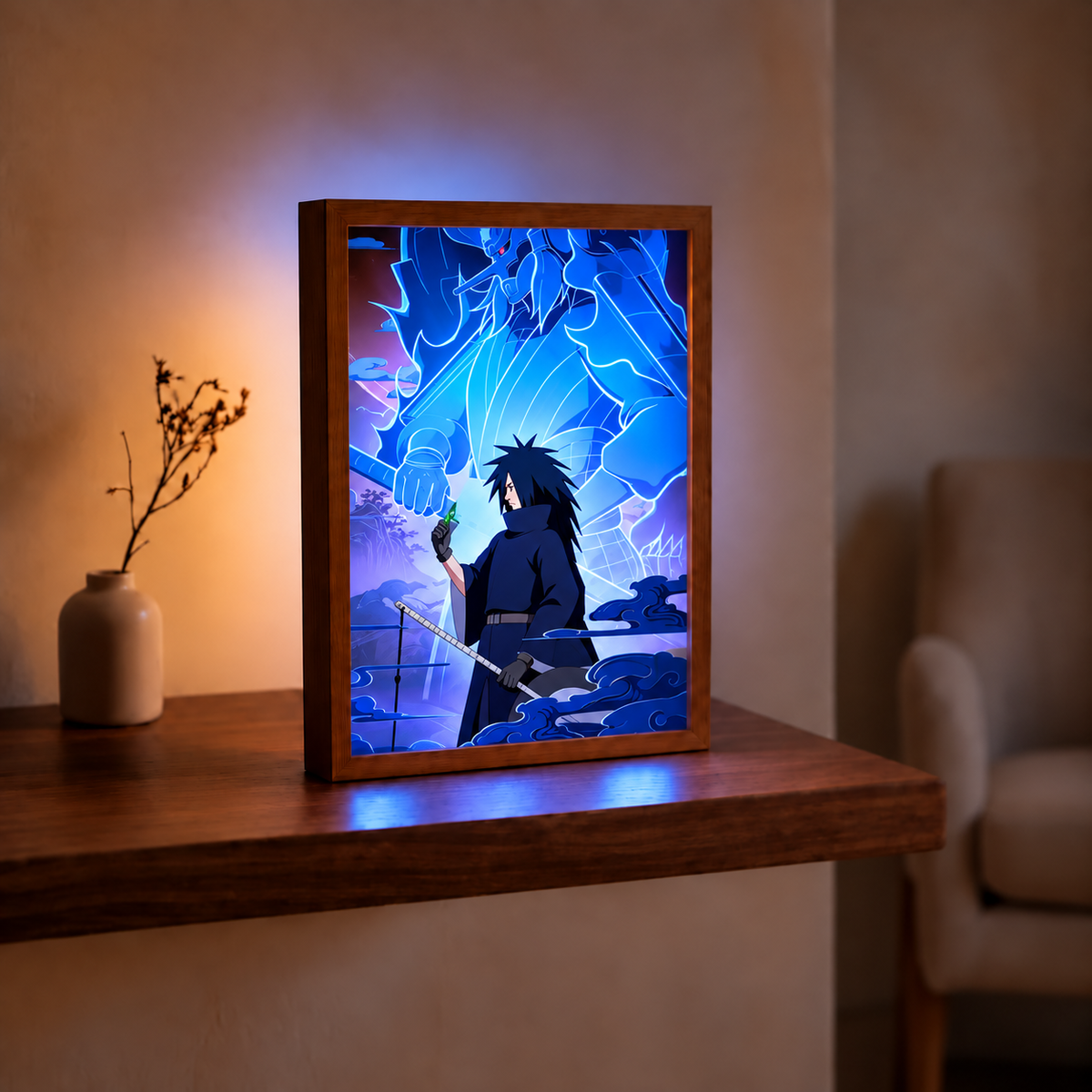 Madara Uchiha and blue Susanoo illuminated artwork in a wooden frame on a table