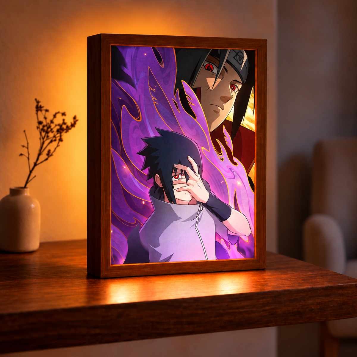 Sasuke and Itachi purple illuminated artwork in a dark wood frame on a wooden table beside a vase