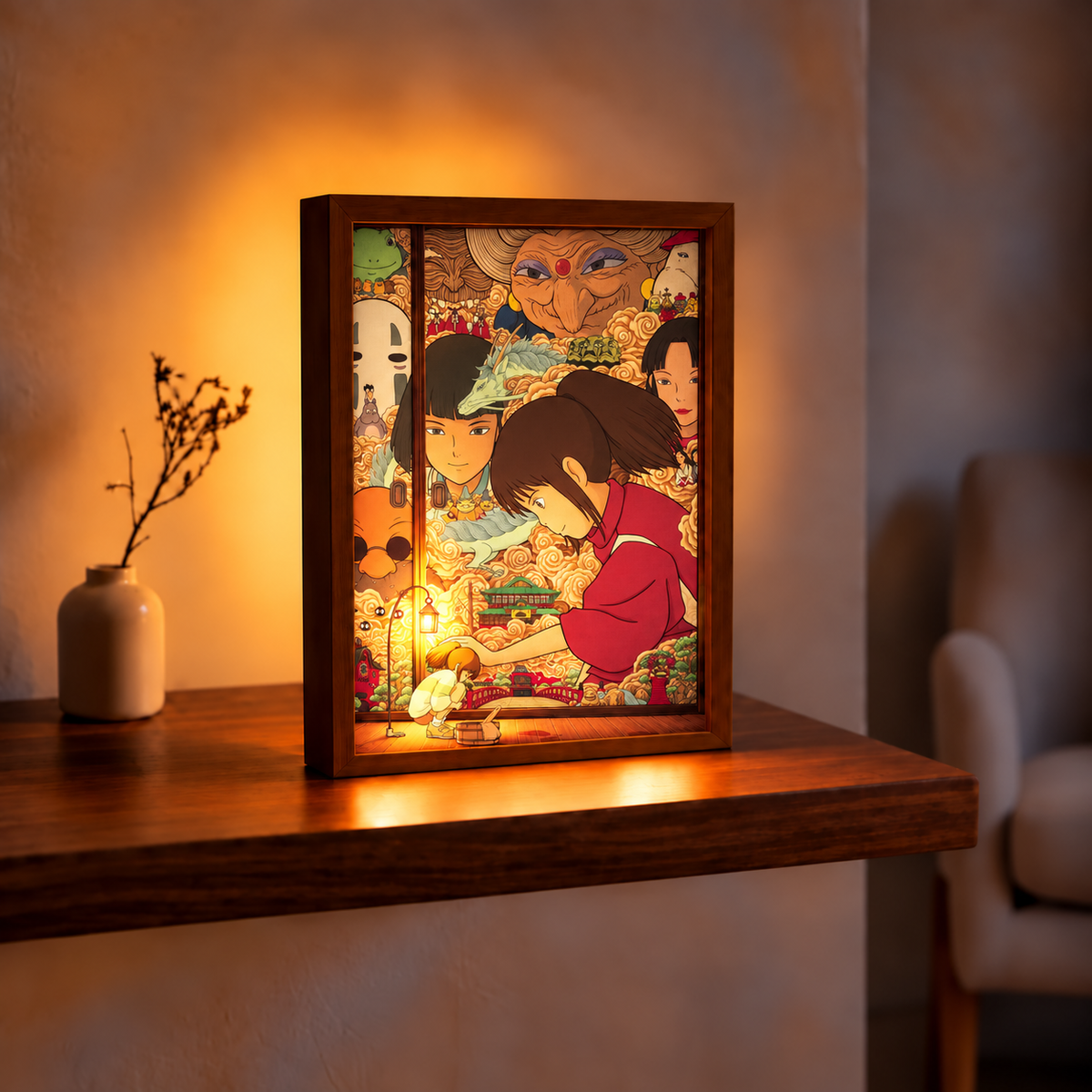 Spirited Away Hidden Memories approved text-free burgundy and gold character artwork backlit in a wooden portrait frame on a warm room table