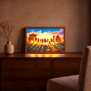 Straw Hat Crew illuminated sunset artwork in a natural wood frame on a walnut cabinet beside a beige vase in a warm living room